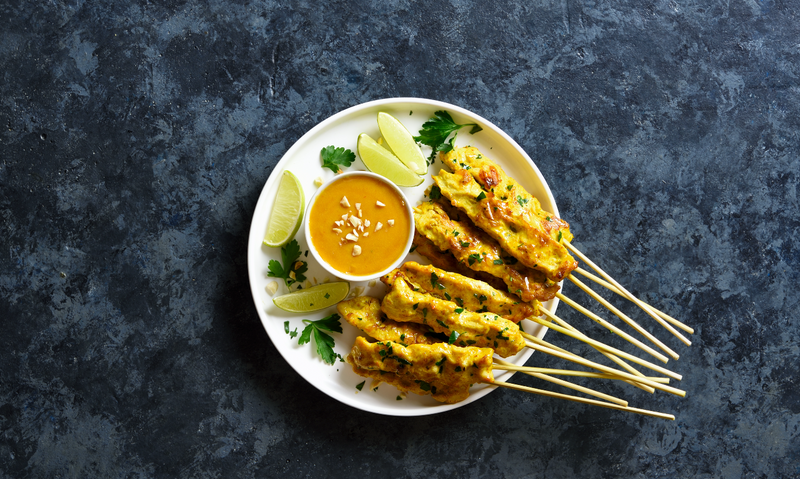 Curried chicken and ginger skewers served with a peanut sauce (x12)
